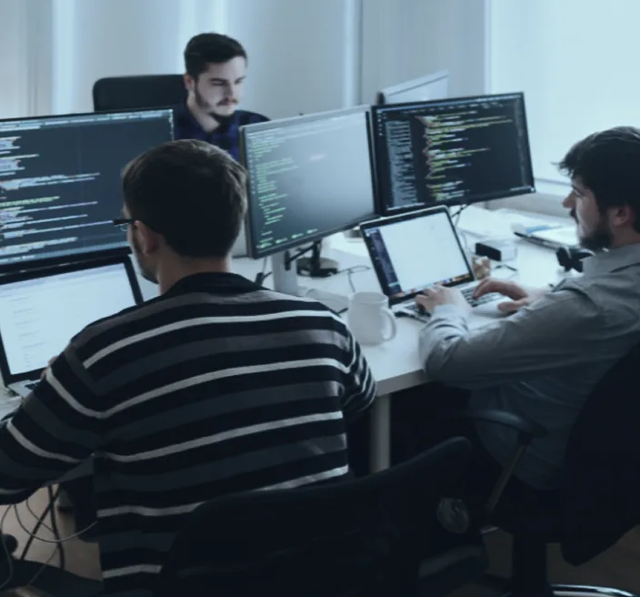 Team collaborating at multiple monitors